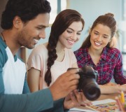 Fashion designers looking at photographs in digital camera